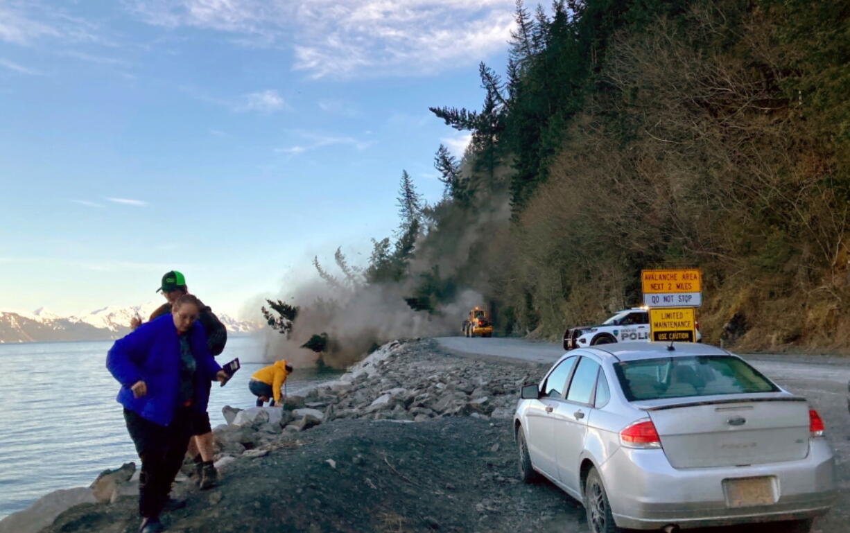 People run from a landslide just outside the downtown area of Seward, Alaska, May 7, 2022. There were no reported injuries in the landslide, which the city estimates could take up to two weeks to clear.