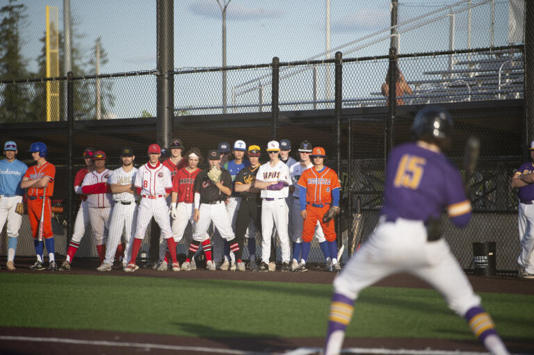 Members of the American League all-stars watch Casey Struckmeier of Columbia River bat during the Clark County All-Star Baseball Series at the Ridgefield Outdoor Recreation Center on Tuesday, May 31, 2022.