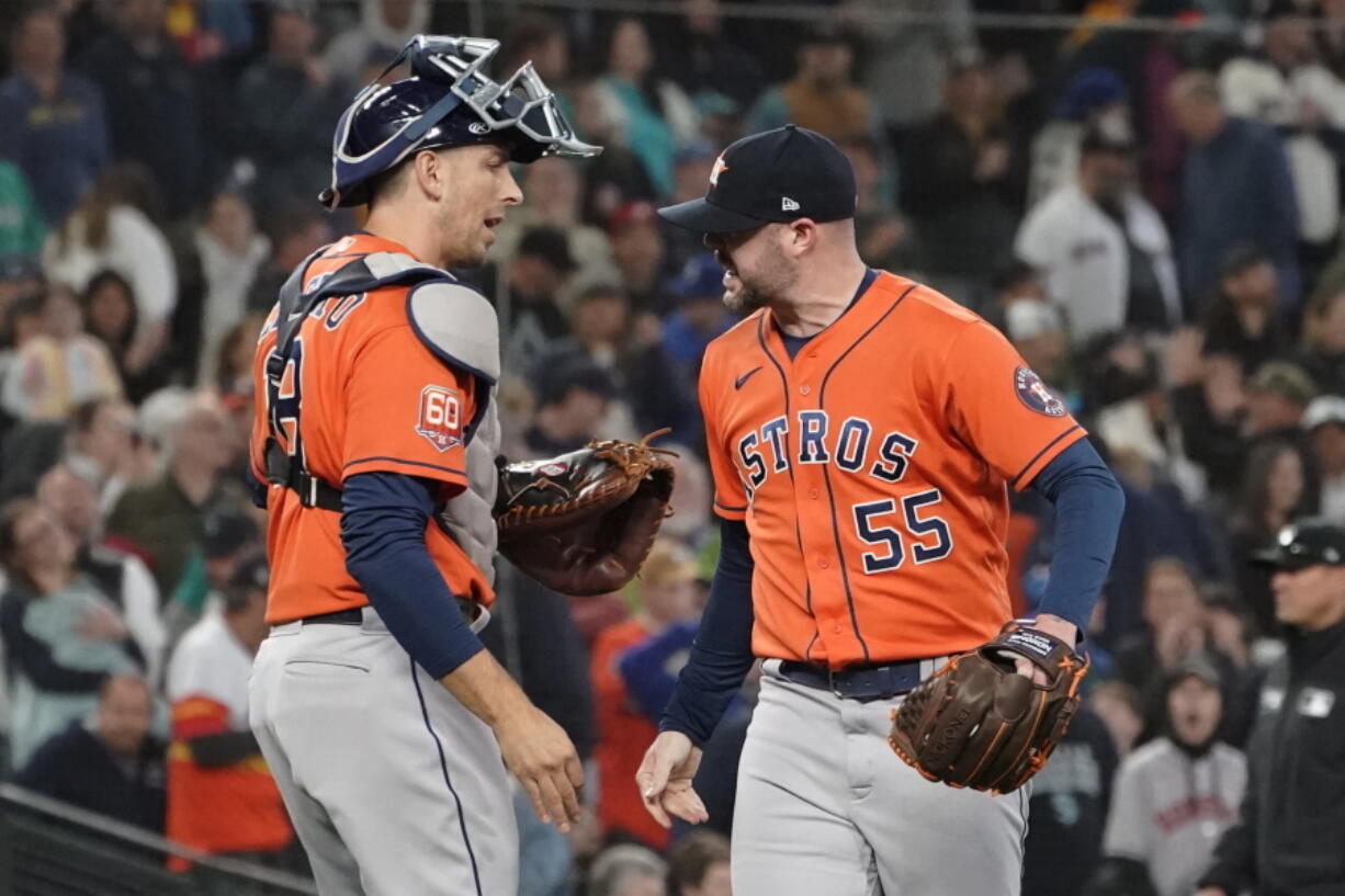 Houston Astros pitcher Ryan Pressly (55) and catcher Martin Maldonado celebrate a win over Seattle on Sunday. (Ted S.