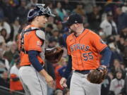 Houston Astros pitcher Ryan Pressly (55) and catcher Martin Maldonado celebrate a win over Seattle on Sunday. (Ted S.