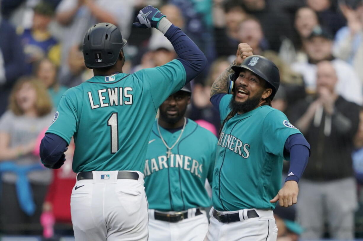 Seattle Mariners' Kyle Lewis (1) is greeted at the dugout by J.P. Crawford, right, after Lewis hit a two-run home run to score Crawford against the Houston Astros during the first inning Friday. (Ted S.