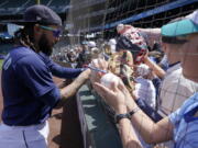 Seattle Mariners shortstop J.P. Crawford signs autographs for young fans before a baseball game against the Oakland Athletics, Wednesday, May 25, 2022, in Seattle. (AP Photo/Ted S.