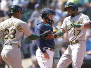 Oakland Athletics' Elvis Andrus (17) greets Christian Bethancourt (23) at the plate after Andrus hit a two-run home run to score Bethancourt during the sixth inning of a baseball game against the Seattle Mariners, Wednesday, May 25, 2022, in Seattle. (AP Photo/Ted S.