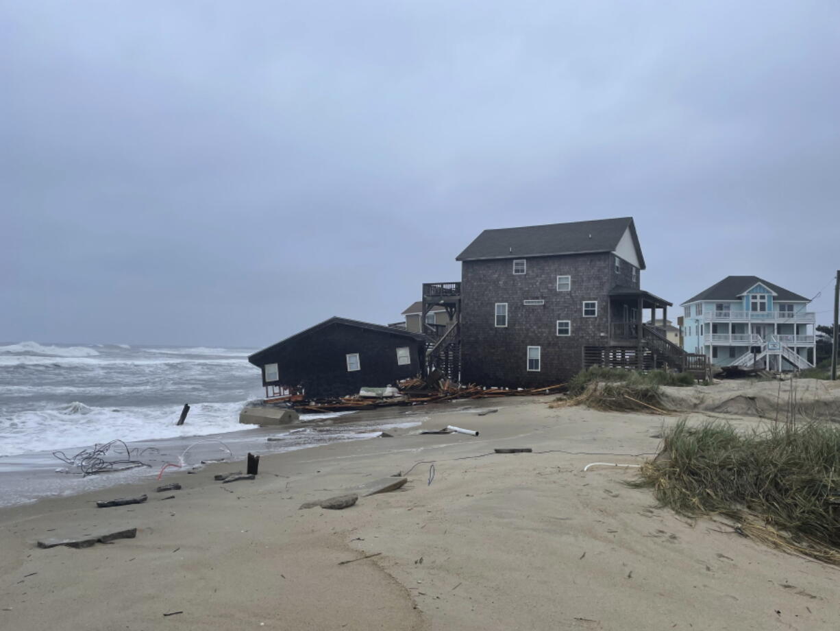 This photo provided by National Park Service shows a beach house collapsing along North Carolina's Outer Banks on Tuesday, May 10, 2022.  Another beach house has fallen into the waves along North Carolina's coast, and more are in danger of collapsing, U.S. National Park Service officials said in a statement Tuesday.  The home that fell was located along Ocean Drive in the Outer Banks community of Rodanthe. The park service has closed off the area and warned that additional homes in the area may fall too.