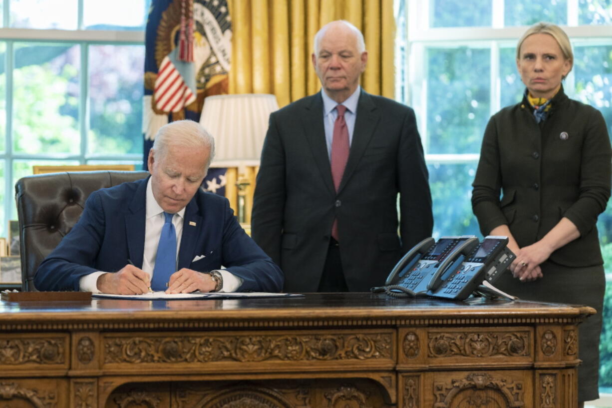 President Joe Biden signs the Ukraine Democracy Defense Lend-Lease Act of 2022 in the Oval Office of the White House, Monday, May 9, 2022, in Washington. Witnessing the signing are Ukraine-born Rep. Victoria Spartz, R-Ind., right, and Sen. Ben Cardin, D-Md.