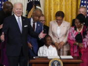 President Joe Biden speaks as Gianna Floyd, the daughter of George Floyd, sits in the chair after Biden signed an executive order in the East Room of the White House, Wednesday, May 25, 2022, in Washington. The order comes on the second anniversary of George Floyd's death, and is focused on policing.