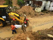 Firefighters carry a body recovered from a landslide triggered by heavy rain in the Jardim Monte Verde neighborhood of Recife in Pernambuco state, Brazil, Sunday, May 29, 2022. Landslides killed at least 84 people in the state of Pernambuco, according to authorities, and more than 1,000 people have been forced from their homes.