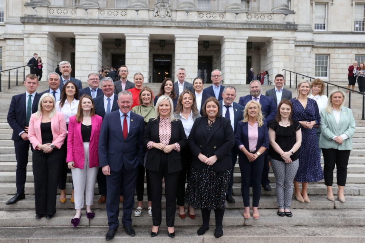 Irish nationalist party Sinn Fein's Michelle O'Neill, center, poses for a family photo with her party's newly elected members of the legislative assembly outside Parliament Buildings at Stormont, Belfast, Northern Ireland, Monday, May 9, 2022. The Irish nationalist party Sinn Fein, which seeks unification with Ireland, hailed a "new era" Saturday for Northern Ireland as it captured the largest number of seats in the Northern Ireland Assembly for the first time in a historic win.