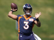 Denver Broncos quarterback Russell Wilson takes part in drills at the NFL football team's voluntary minicamp Wednesday, April 27, 2022, at the team's headquarters in Englewood, Colo.