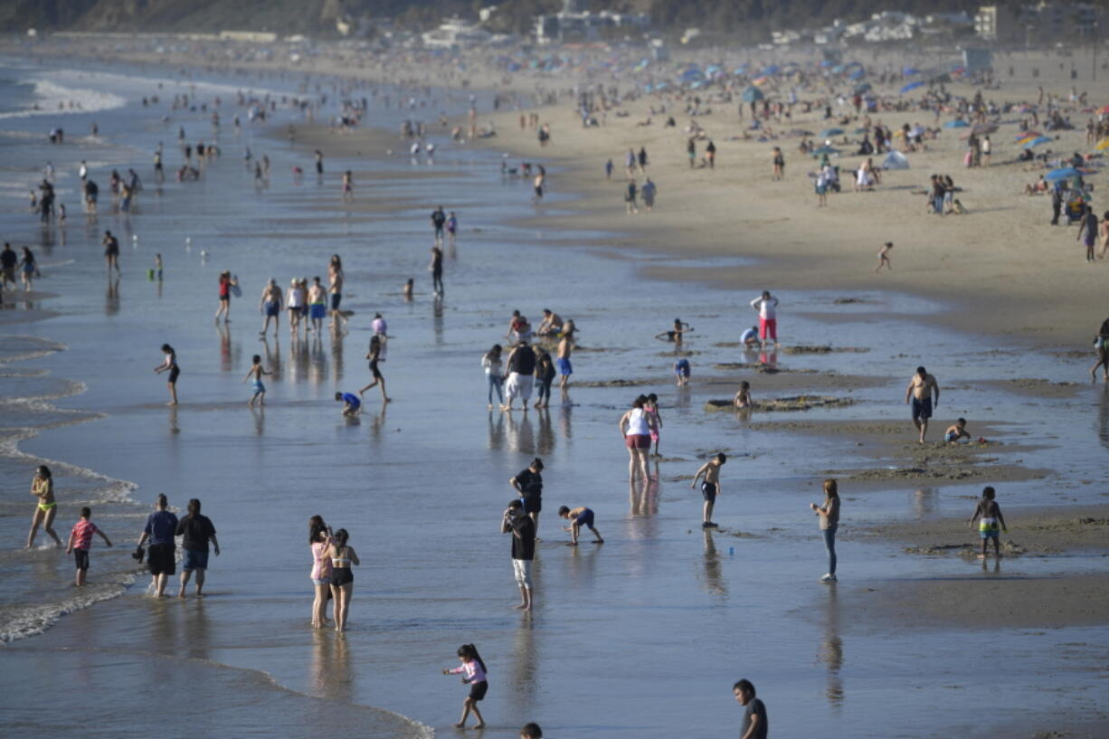 FILE -- People enjoy the beach, Feb. 12, 2022, Santa Monica, Calif. California's population continued to shrink in 2021 as the nation's most populous state posted its second consecutive decline, state officials said Monday, May 2, 2022.