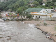 FILE - Floodwaters wash through a property near Durban, South Africa, Tuesday, April 23, 2019. The fatal floods that wreaked havoc in South Africa in mid-April this year have been attributed to climate change, an analysis published Friday, May 13, 2022 by a team of leading climate scientists said.The World Weather Attribution group analyzed both historical and emerging sets of data from the catastrophic rainfall that led to floods which triggered massive landslides in the Eastern Cape and Kwa-Zulu Natal provinces of South Africa.