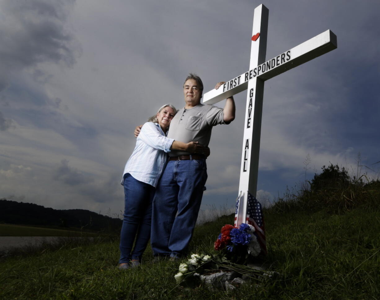 FILE - In this Aug. 6, 2019, photo, Ansol and Janie Clark pose at a memorial Ansol Clark constructed near the Kingston Fossil Plant in Kingston, Tenn. The Tennessee Valley Authority was responsible for a massive coal ash spill at the plant in 2008 that covered a community and fouled rivers. The couple says the memorial is for the workers who have come down with illnesses, some fatal, including cancers of the lung, brain, blood and skin and chronic obstructive pulmonary disease. Ansol Clark who drove a fuel truck for four years at the cleanup site, and suffered from a rare blood cancer, has also died now.