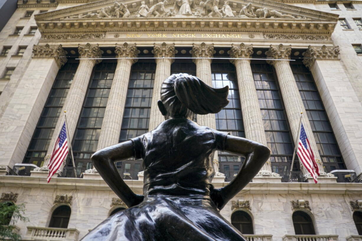 FILE- In this Aug. 25, 2020, file photo, the 'Fearless Girl' bronze sculpture, commissioned by State Street Global Advisors, looks towards the New York Stock Exchange from its roadside perch in New York. Amid the push to get U.S. boardrooms to look more like companies' customers and employees, advocates are finally seeing just how steep the task will be.  Boards of directors at publicly traded U.S. companies are much more white and much less diverse than the overall population, often starkly so.