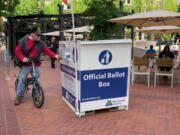 A voter drops off a ballot at a box in Pioneer Courthouse Square in Portland, Ore., Tuesday, May, 17, 2022. The state is holding its primary elections.