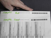 An election worker at the Clackamas County Elections office shows barcodes on ballots that is bad, top, and good on Thursday, May 19, 2022, Oregon City, Ore. Ballots with blurry barcodes that can't be read by vote-counting machines will delay election results by weeks in a key U.S. House race in Oregon's primary.