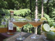 Cocktails containing alcohol and syrup infusions sit amid bottles and mixing accessories in Allison Park, Pa., on July 4, 2021. Alcohol and syrup infusions are growing in popularity and are relatively simple to incorporate into home bars.