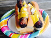 Yellow mustard on top of a pair of grilled hotdogs. Mustards are made around the world and with all kinds of ingredients besides mustard seeds. Try picking up local mustards when you travel.