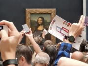 A security guard cleans the smeared cream from the glass protecting the Mona Lisa at the Louvre Museum, in Paris, France, Sunday, May 29, 2022. A man seemingly disguised as an old woman in a wheelchair threw a piece of cake at the glass protecting the Mona Lisa and shouted at people to think of planet Earth. The Paris prosecutor's office said Monday, May 30, 2022 that the man, 36, was detained following Sunday's incident and sent to a police psychiatric unit, and that it had opened an investigation into the damage of cultural artifacts.