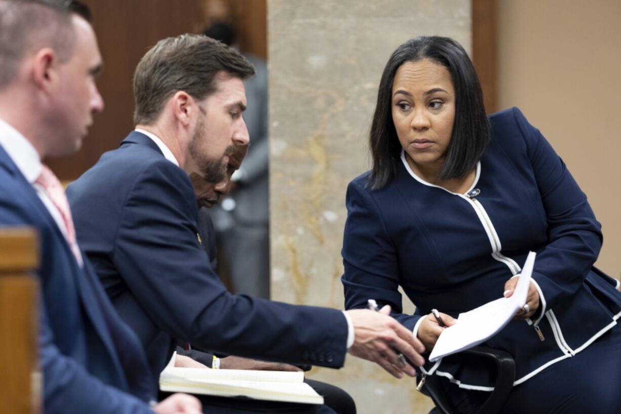 Fulton County District Attorney Fani Willis, right, talks with a member of her team during proceedings to seat a special purpose grand jury in Fulton County, Georgia, on Monday, May 2, 2022, to look into the actions of former President Donald Trump and his supporters who tried to overturn the results of the 2020 election. The hearing took place in Atlanta.