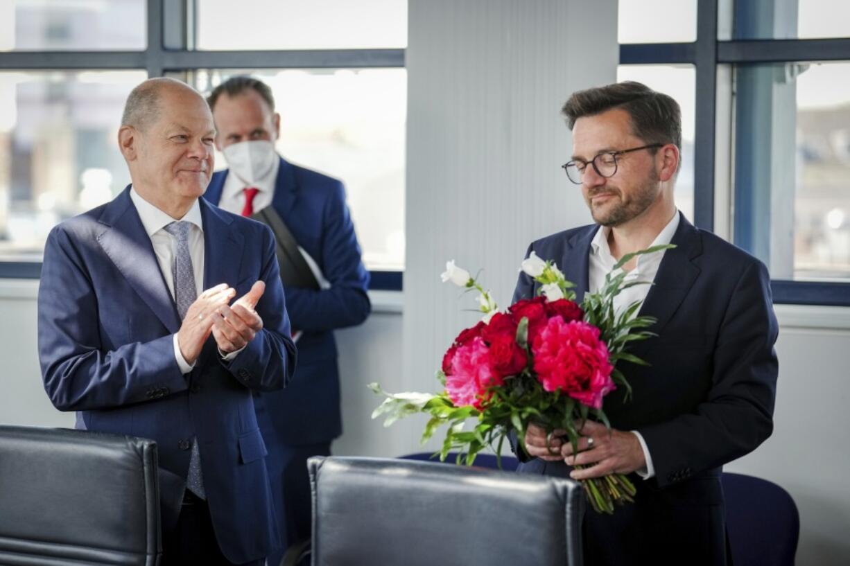 Chancellor Olaf Scholz, left, applauds Thomas Kutschaty, SPD's top candidate in the state election in North Rhine-Westphalia, at the start of their party's executive committee meeting at party headquarters in Berlin, Germany, Monday, May 16, 2022. The SPD received 26.7 percent of the vote in the NRW election.