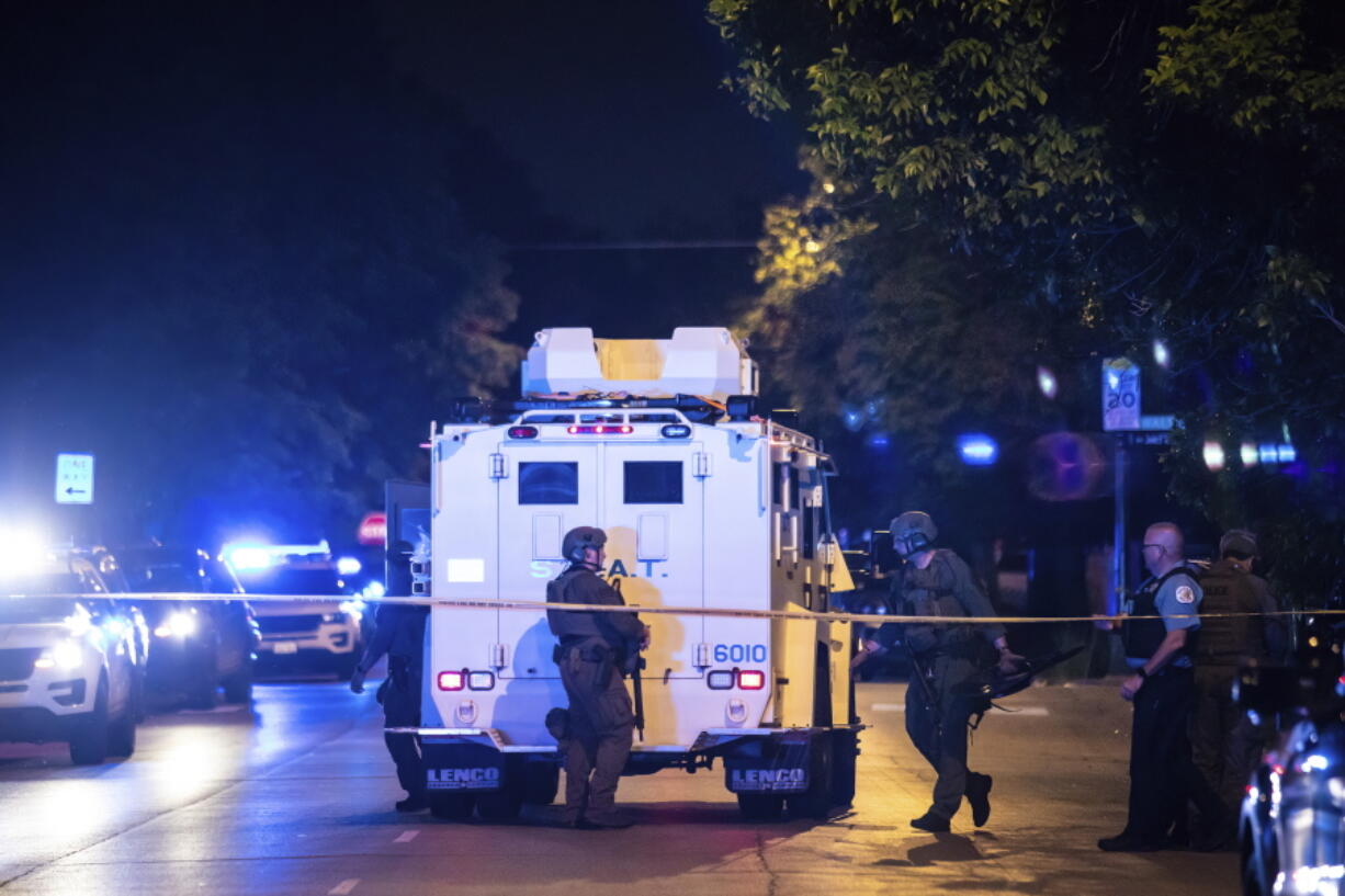 Chicago police and SWAT officers investigate on the 4400 block of West Walton Street where an alleged gunman barricaded himself in a building after one man was killed and three other people were wounded in a shooting in West Humboldt Park on the West Side, Sunday night, May 29, 2022, in Chicago. The suspect also suffered a gunshot wound in the incident, but officers didn't fire any shots, police said.