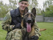 Sgt. 1st Class Balazs Nemeth poses with his bomb-sniffing dog Logan on April 28 at the garrison of the ordnance-disposal and warship regiment of the Hungarian Defense Forces in Budapest. Logan, a 2-year-old Belgian shepherd, has received a second chance after being rescued from abusive owners: He's been recruited to serve in an elite military bomb squad.