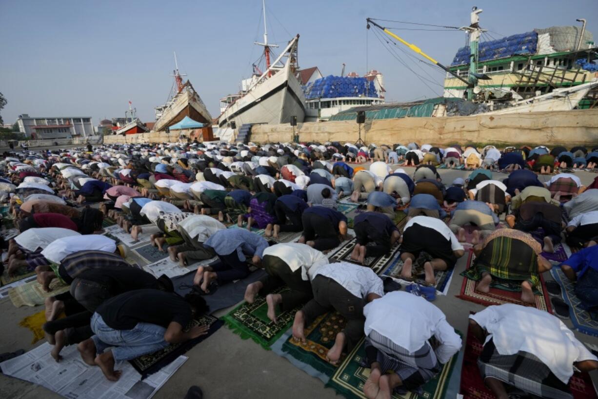 Muslim men offer Eid al-Fitr prayers to mark the end of the holy fasting month of Ramadan at Sunda Kelapa port in Jakarta, Indonesia, Monday, May 2, 2022.