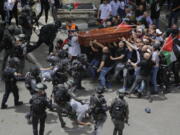 FILE - Israeli police confront mourners as they carry the casket of slain Al Jazeera veteran journalist Shireen Abu Akleh during her funeral in east Jerusalem, Friday, May 13, 2022. Latin Patriarch Pierbattista Pizzaballa, the top Catholic clergyman in the Holy Land, told reporters at St. Joseph Hospital in Jerusalem on Monday that the police beating mourners as they carried Shireen Abu Akleh's her casket was a disproportionate use of force that "disrespected" the Catholic Church. He added that Israel committed a "severe violation" of international norms.