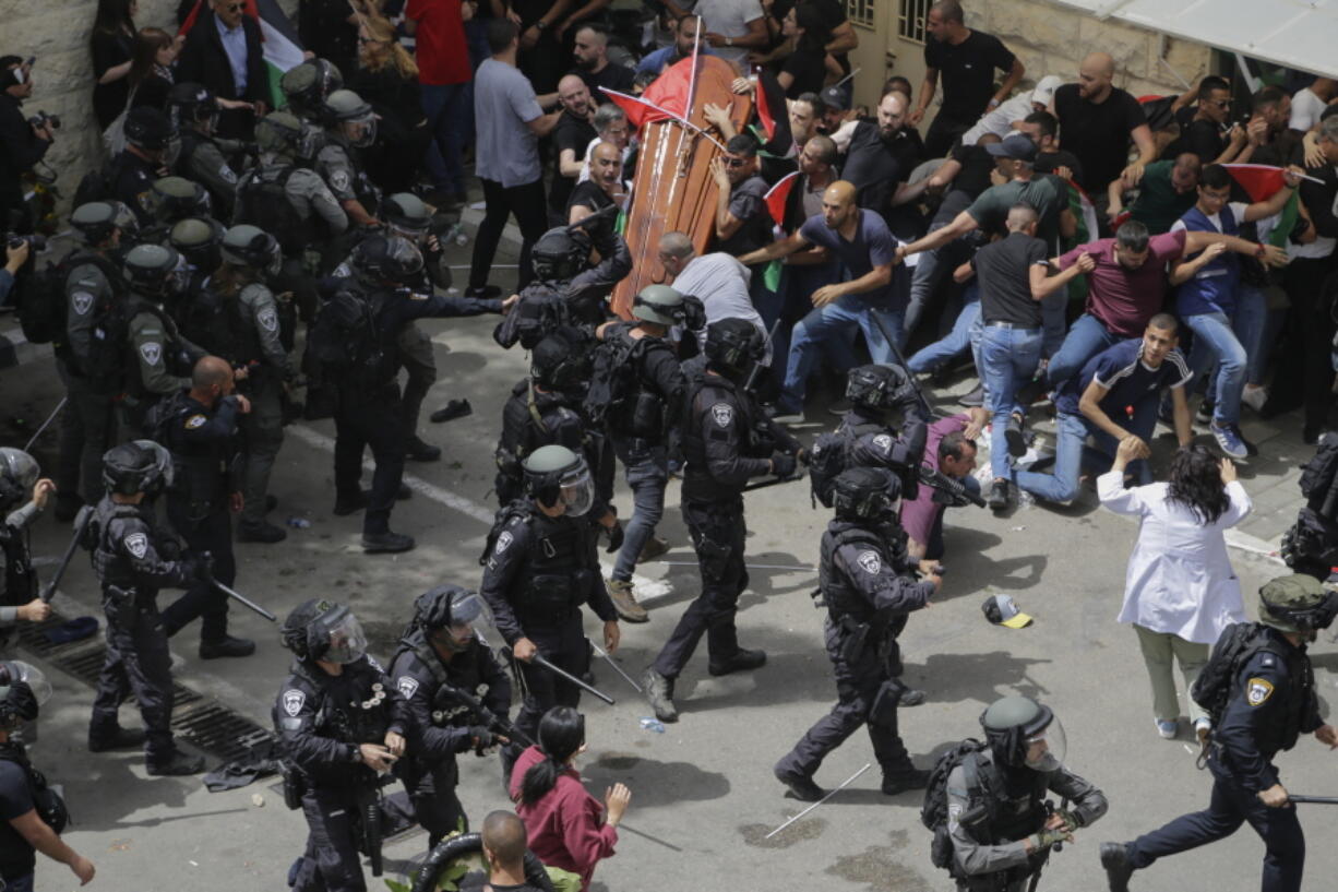 Israeli police confront with mourners as they carry the casket of slain Al Jazeera veteran journalist Shireen Abu Akleh during her funeral in east Jerusalem, Friday, May 13, 2022. Abu Akleh, a Palestinian-American reporter who covered the Mideast conflict for more than 25 years, was shot dead Wednesday during an Israeli military raid in the West Bank town of Jenin.