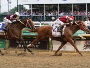 Rich Strike (21), with Sonny Leon aboard, beats Epicenter (3), with Joel Rosario aboard, at the finish line to win the 148th running of the Kentucky Derby horse race at Churchill Downs Saturday, May 7, 2022, in Louisville, Ky.