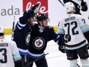 Winnipeg Jets' Blake Wheeler (26) celebrates his goal against the Seattle Kraken with Nikolaj Ehlers (27) during the third period of NHL hockey game action in Winnipeg, Manitoba, Sunday, May 1, 2022.