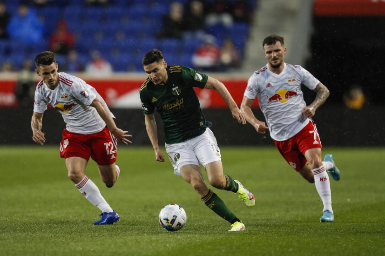 Portland Timbers forward Jaroslaw Niezgoda (11), center, tries to control the ball under the pressure of New York Red Bulls defenders Dylan Nealis (12) and Thomas Edwards (7) during the first half of an MLS soccer match, Saturday, May 7, 2022, in Harrison, N.J.