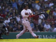 Boston Red Sox's Rafael Devers, right, watches his home run in the third inning in a baseball game against the Seattle Mariners, Saturday, May 21, 2022, in Boston. (AP Photo/Robert F.