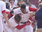 Boston Red Sox's Franchy Cordero, center, celebrates with teammates after hitting a grand slam in the tenth inning of a baseball game against the Seattle Mariners, Sunday, May 22, 2022, in Boston. The Red Sox won 8-4.