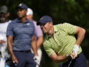 Rory McIlroy, of Northern Ireland, watches his tee shot as Tiger Woods looks on, on the 17th hole during the first round of the PGA Championship golf tournament, Thursday, May 19, 2022, in Tulsa, Okla.