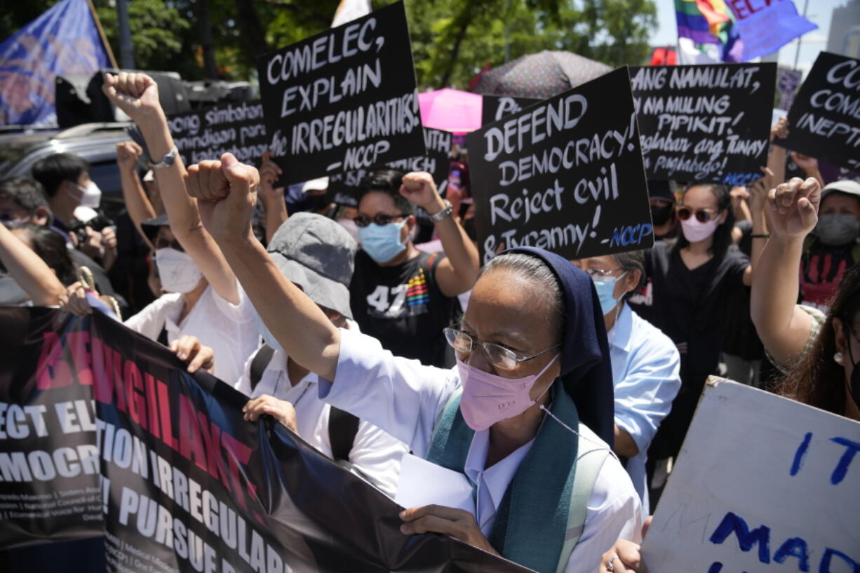 A Catholic nun clenches her fist as she joins protesters against presidential frontrunner Ferdinand "Bongbong" Marcos and running mate Sara Duterte, daughter of the current president, during a rally in Pasay, Philippines, Friday, May 13, 2022. Allies of the Philippines' presumptive next president, Marcos Jr., appear set to strongly dominate both chambers of Congress, further alarming activists after the late dictator's son scored an apparent election victory that will restore his family to the seat of power.