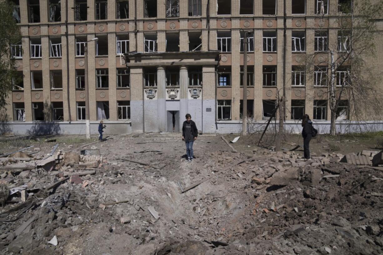 CAPTION CORRECTS THE LOCATION - A woman looks on a crater of an explosion after Russian airstrike in Kostyantynivka, Donetsk region, Ukraine, Saturday, May 7, 2022.