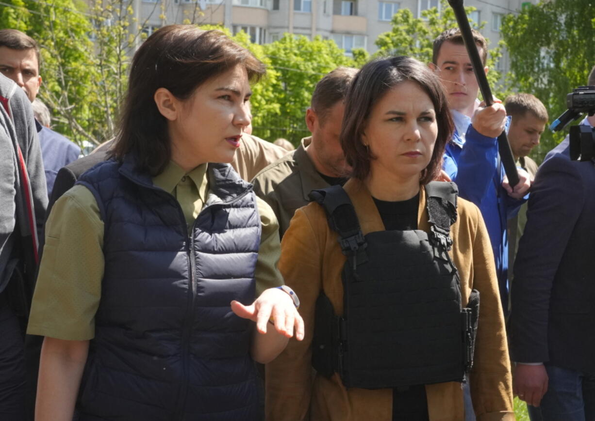 German Foreign Minister Annalena Baerbock, right, and Ukrainian Prosecutor General Iryna Venediktova talk as they visit a mass grave in Bucha, on the outskirts of Kyiv, Ukraine, Tuesday, May 10, 2022.