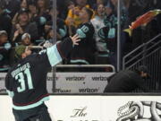 Seattle Kraken goaltender Philipp Grubauer tosses a stuffed salmon to fans after the team's NHL hockey game against the San Jose Sharks, Friday, April 29, 2022, in Seattle. The Kraken won 3-0. (AP Photo/Ted S.