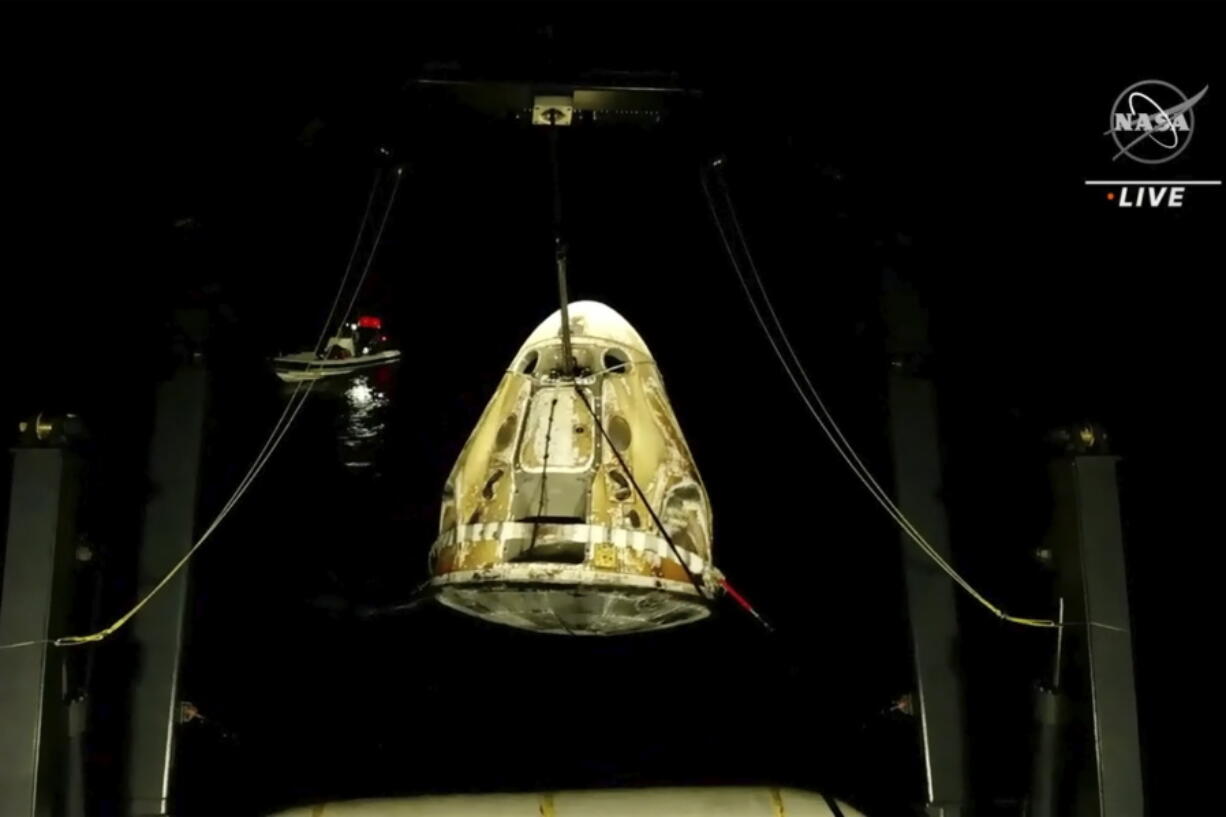 In this image made from video supplied by NASA, SpaceX Dragon space capsule is lifted out of the water after splashing down in the Gulf of Mexico early Friday, May 6, 2022. NASA's Raja Chari, Tom Marshburn and Kayla Barron, and the European Space Agency's Matthias Maurer undocked from the International Space Station less than 24 hours earlier.