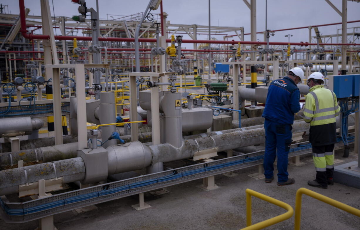 FILE - Operators work at Enagas regasification plant, the largest LNG plant in Europe, in Barcelona, Spain, Tuesday, March 29, 2022. The Spanish government on Friday approved a new plan aimed at reining in soaring energy prices, signing off on a temporary cap on natural gas prices that it said would immediately reduce costs for a third of domestic consumers and 70% of industry.