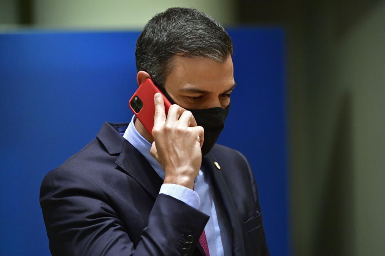 FILE - Spain's Prime Minister Pedro Sanchez speaks on his cell phone during a round table meeting at an EU summit in Brussels, on July 20, 2020. Spain's government has fired the director of its top intelligence agency amid two separate cases of the hacking of politicians' cellphones, Spanish media reports said Tuesday.