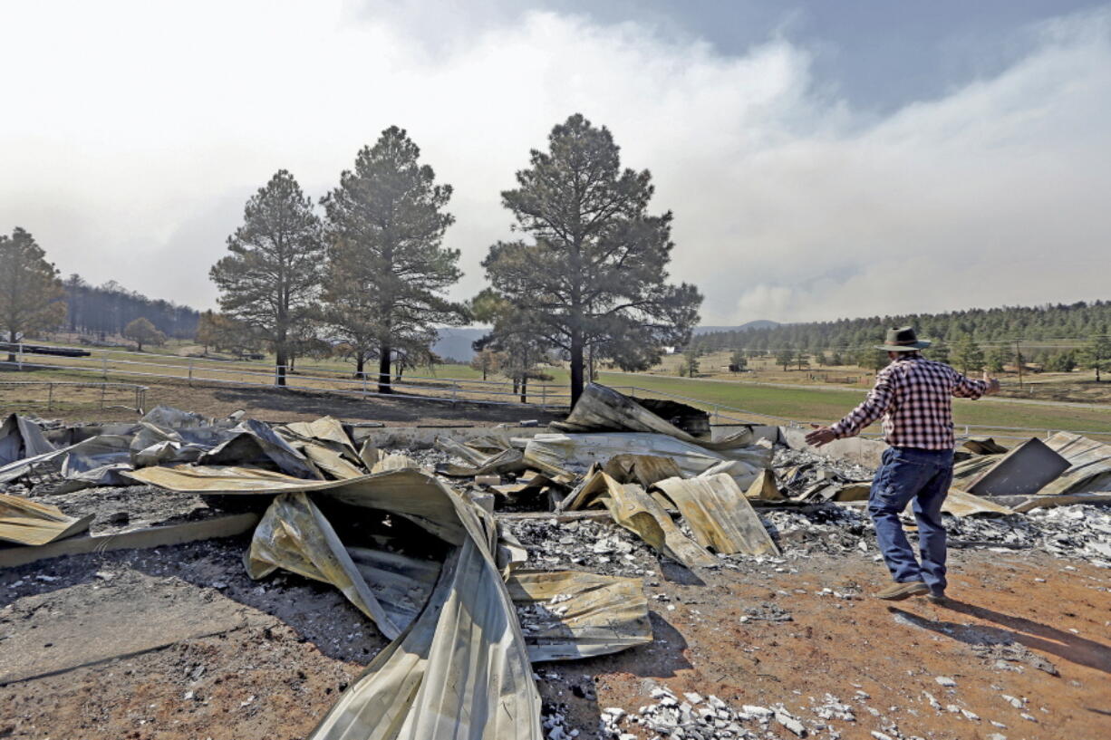 Jerry Gomez looks through the remains of his home, destroyed by a wildfire, Tuesday in Rociada, N.M.