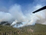 In this photo provided by the New Mexico National Guard, a New Mexico National Guard Aviation UH-60 Black Hawk flies as part of firefighting efforts, dropping thousands of gallons of water with Bambi buckets from the air on the Calf Canyon/Hermits Peak fire in northern New Mexico on Sunday, May, 1, 2022. Thousands of firefighters are battling destructive wildfires in the Southwest as more residents are preparing to evacuate.