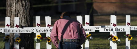 Pastor Daniel Myers kneels in front of crosses bearing the names of Tuesday's shooting victims while praying for them at Robb Elementary School in Uvalde, Texas, Thursday, May 26, 2022. (AP Photo/Jae C.