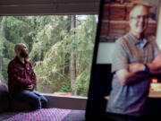 Nathan Lambrecht is photographed next to a picture of his father, Doug Lambrecht, at his apartment in Woodinville, Wash., Monday, March 21, 2022. The 71-year-old retired physician was among the first of the nearly 1 million Americans to die from COVID-19. "I'm afraid that as the numbers get bigger, people are going to care less and less," Nathan said.