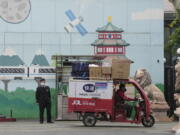 A delivery man past through the entrance to a community on Tuesday, May 10, 2022, in Beijing. China's capital began another round of three days of mass testing for millions of its residents Tuesday in a bid to prevent an outbreak from growing to Shanghai proportions.