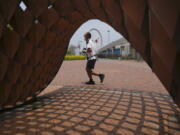 A man jogs in a park in Hong Kong, Thursday , May 5, 2022. Hong Kong on Thursday reopened beaches and pools in a relaxation of COVID-19 restrictions, while China's capital Beijing began easing quarantine rules for arrivals from overseas.