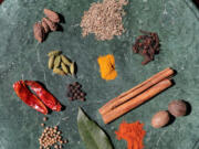 Curry comes from different regions of the world and can be made with ingredients such as: top, from left: black cardamom pods, cumin seeds; second row: green cardamom pods, ground turmeric, cloves; third row: dried red peppers, black peppercorns, cinnamon sticks; fourth row: coriander seeds, bay leaf, paprika, nutmeg. (Photos by Hillary Levin/St.