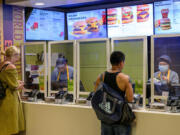 Employees serve customers May 27 at a McDonald's fast food restaurant in New York.